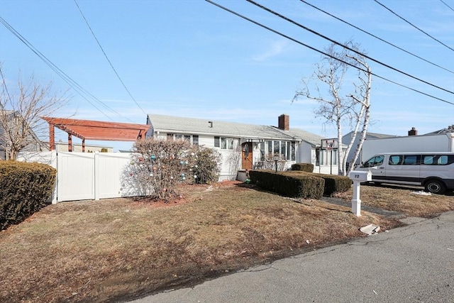 view of front of home featuring a front yard, fence, and a pergola