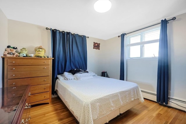 bedroom with a baseboard radiator and wood finished floors