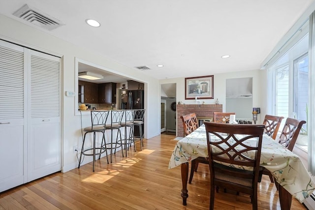 dining area featuring light wood finished floors, visible vents, and recessed lighting