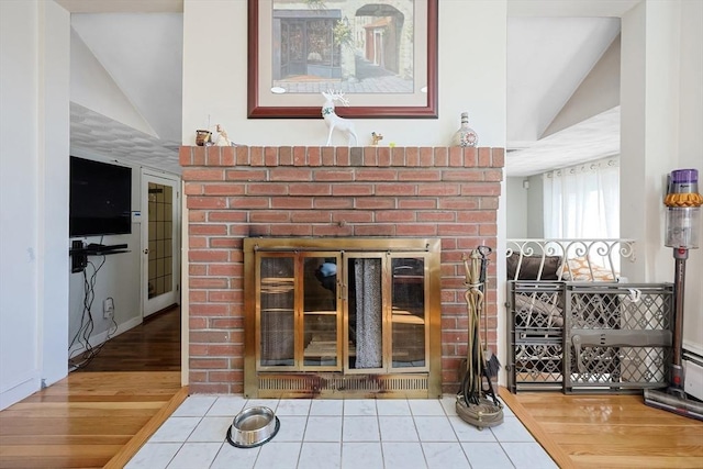 interior details featuring a brick fireplace and hardwood / wood-style floors