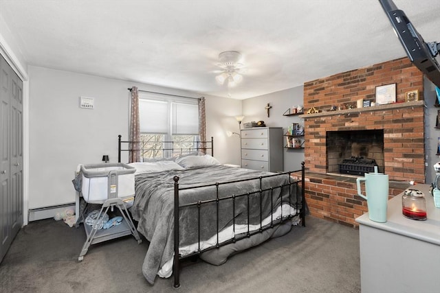 carpeted bedroom with a baseboard heating unit, a brick fireplace, and a closet