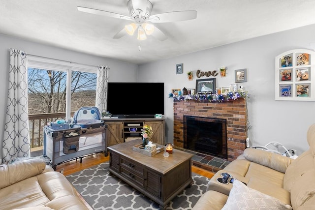 living room featuring a brick fireplace, dark wood finished floors, and a ceiling fan