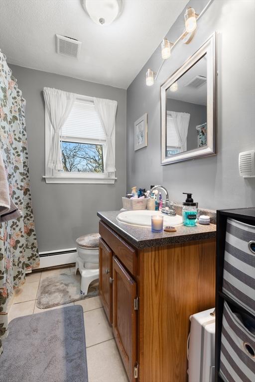 full bath featuring vanity, visible vents, tile patterned flooring, toilet, and baseboard heating