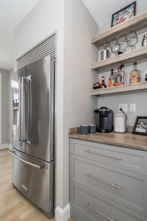 kitchen featuring gray cabinetry, light wood-style flooring, high end fridge, and open shelves