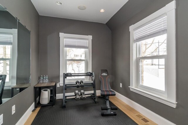 workout room with recessed lighting, baseboards, and wood finished floors