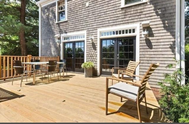 wooden terrace with french doors and outdoor dining area
