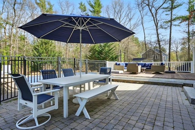 view of patio with fence, a wooden deck, outdoor dining area, and outdoor lounge area