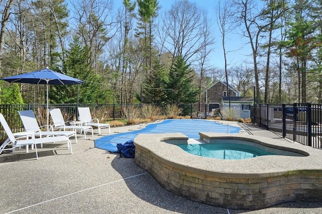 view of swimming pool with a patio area, an in ground hot tub, fence, and a fenced in pool