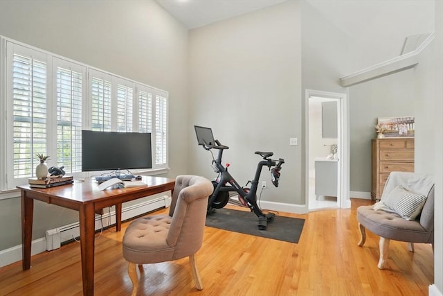 office with baseboards, a baseboard heating unit, and a towering ceiling