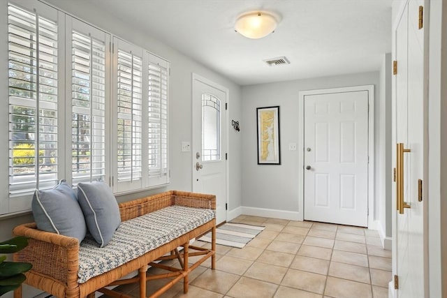 foyer featuring light tile patterned flooring, baseboards, and visible vents