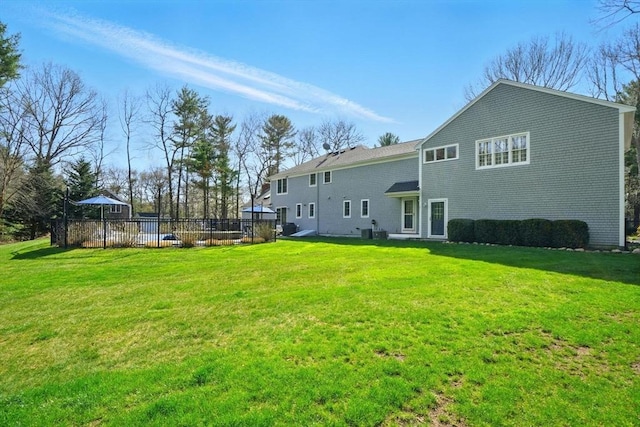 back of house with fence and a lawn