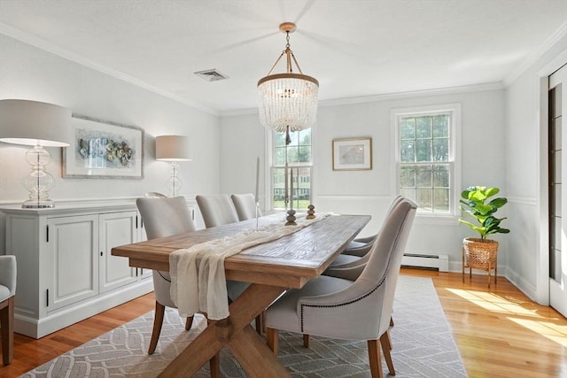 dining room with a healthy amount of sunlight, baseboard heating, a notable chandelier, and visible vents