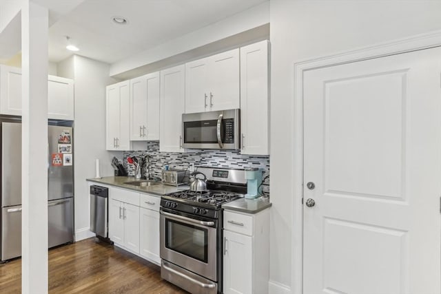 200 W 8th St Unit 1, Boston, MA 02127 - kitchen with appliances with stainless steel finishes, backsplash, white cabinetry, dark wood finished floors, and recessed lighting