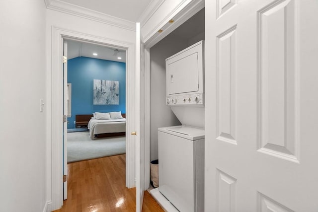 138 Worcester Ln, Waltham, MA 02451 - clothes washing area featuring estacked washer and dryer, light wood-style flooring, and ornamental molding