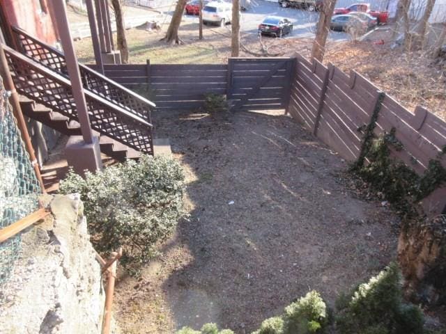 view of yard featuring fence and stairs