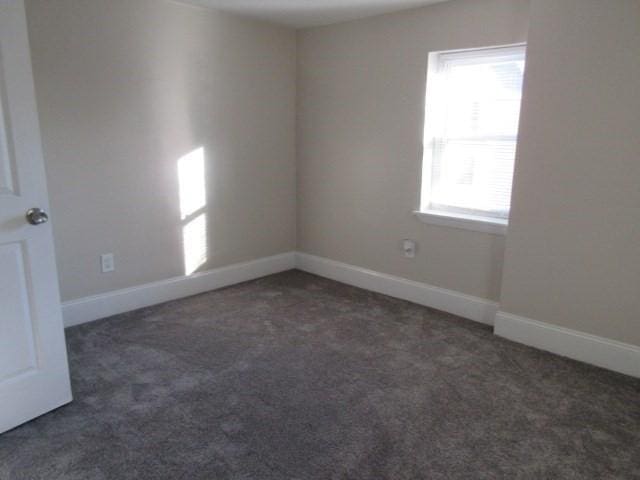 carpeted spare room with baseboards