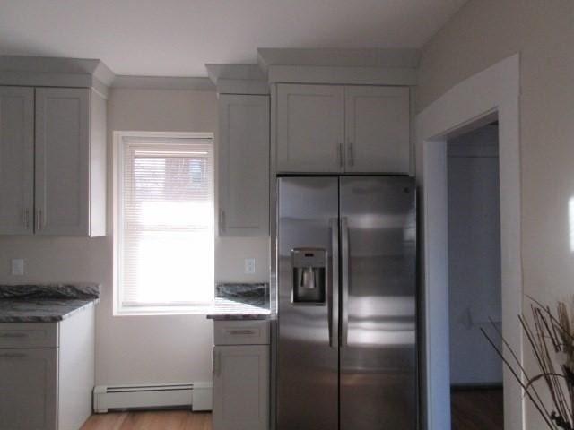 kitchen featuring stainless steel refrigerator with ice dispenser, a baseboard radiator, and light wood-style flooring