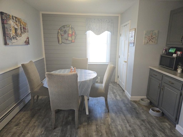 dining space featuring dark hardwood / wood-style flooring and a baseboard heating unit