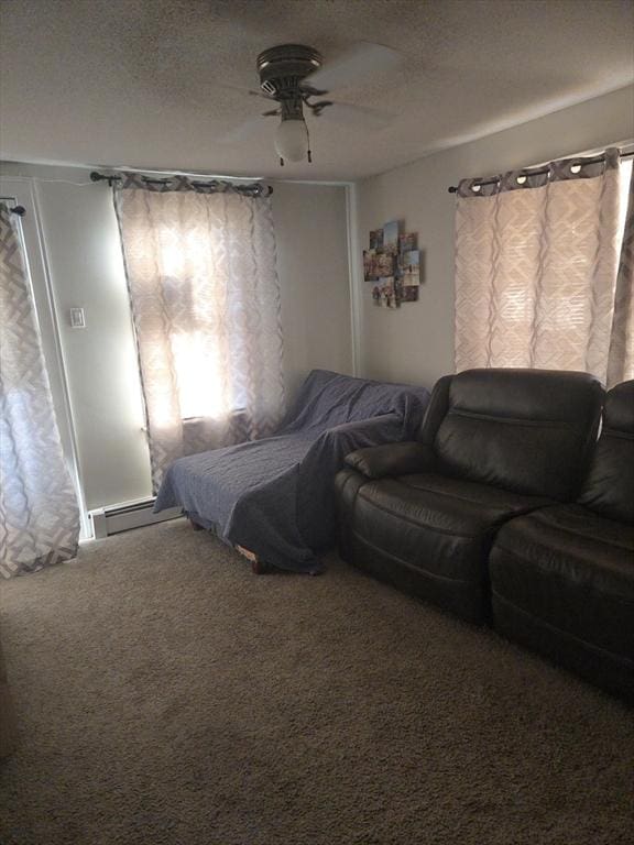 carpeted bedroom featuring ceiling fan, a textured ceiling, and a baseboard heating unit