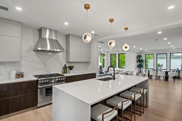 116 Thorndike Rd, Brookline, MA 02446 - kitchen featuring wall chimney range hood, high end range, modern cabinets, light wood-style floors, and recessed lighting