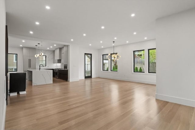116 Thorndike Rd, Brookline, MA 02446 - unfurnished living room with a chandelier, light wood-style flooring, and recessed lighting