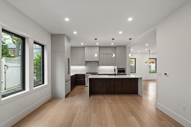 116 Thorndike Rd, Brookline, MA 02446 - kitchen with modern cabinets, high quality appliances, light countertops, light wood-style floors, and tasteful backsplash