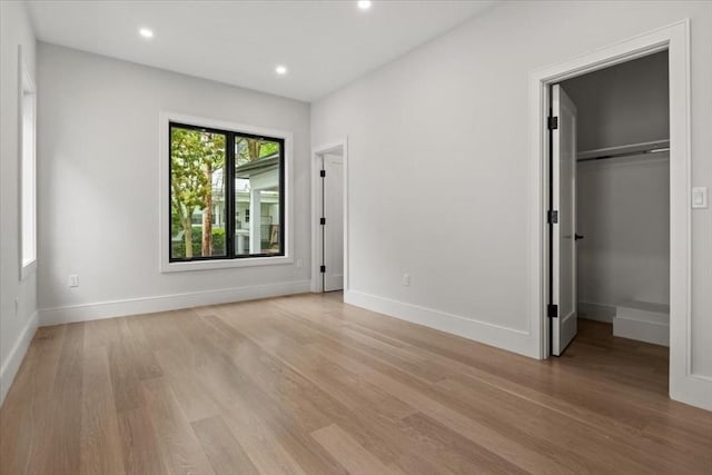 116 Thorndike Rd, Brookline, MA 02446 - unfurnished bedroom featuring light wood-style floors, recessed lighting, a walk in closet, and a closet