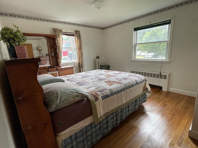 45 Leonard St, Dedham, MA 02026 - bedroom with radiator, wood finished floors, and multiple windows