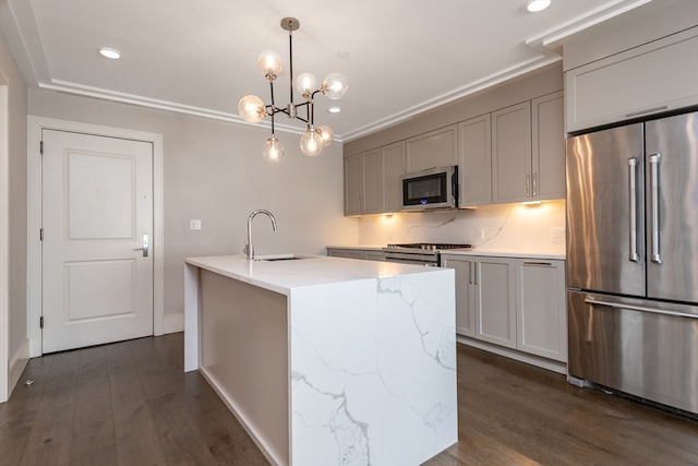 kitchen with decorative light fixtures, light stone counters, sink, dark wood-type flooring, and appliances with stainless steel finishes