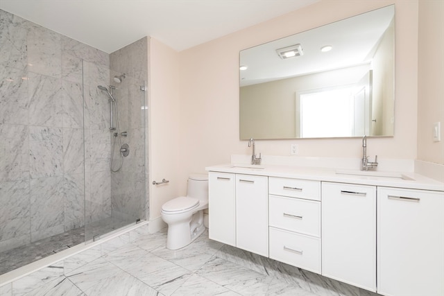 bathroom with tiled shower, vanity, and toilet