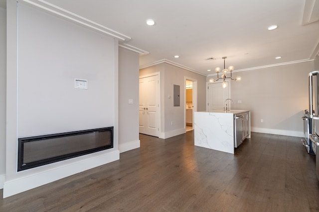 unfurnished living room featuring dark hardwood / wood-style floors, an inviting chandelier, crown molding, and sink