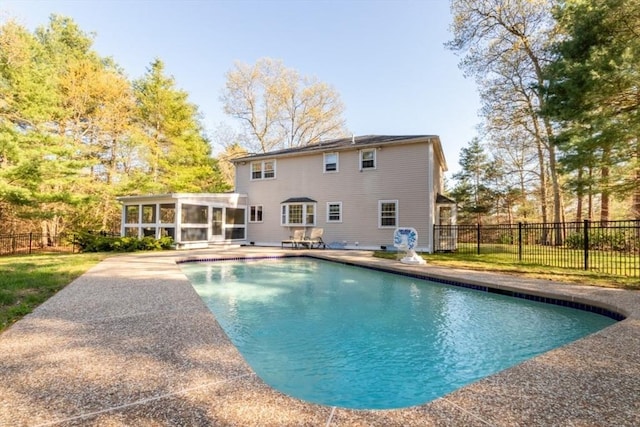 view of swimming pool with a sunroom, fence, a fenced in pool, and a patio