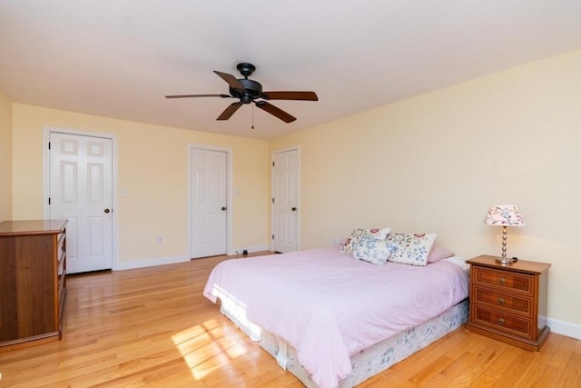 bedroom with a ceiling fan, baseboards, and light wood-type flooring
