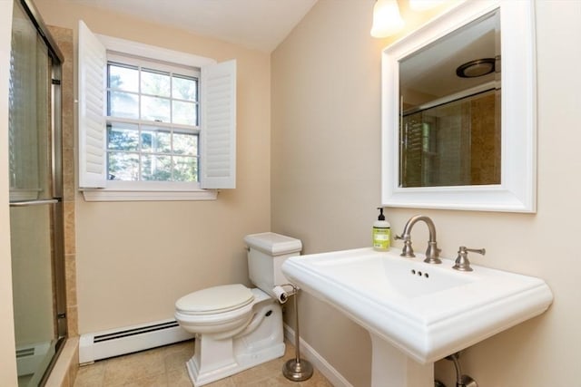 bathroom featuring a sink, baseboards, a baseboard heating unit, toilet, and tiled shower