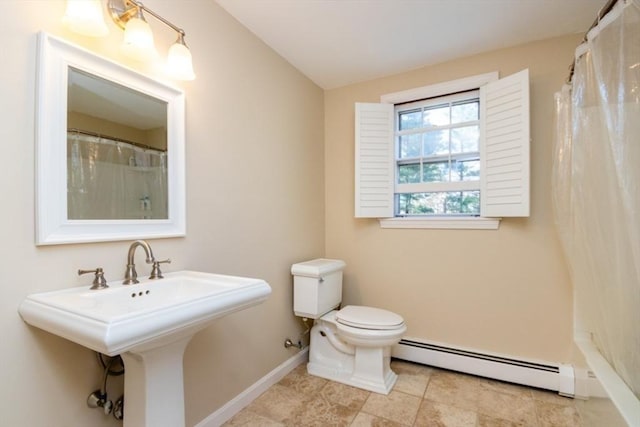 full bath featuring baseboard heating, vaulted ceiling, a sink, baseboards, and toilet