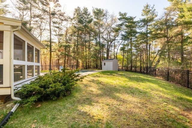 view of yard featuring a fenced backyard, an outdoor structure, a sunroom, and a shed