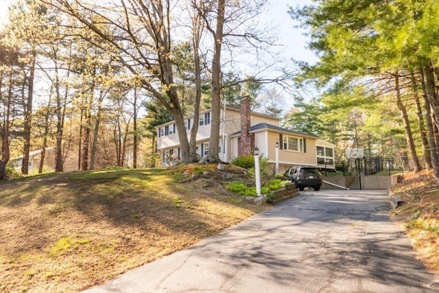 view of side of property featuring driveway and a chimney