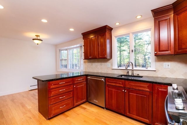 kitchen with dishwasher, a sink, a baseboard heating unit, a peninsula, and light wood-style floors