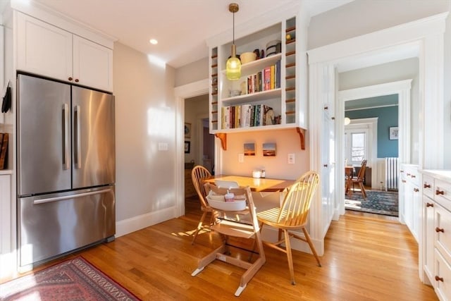 dining area featuring radiator, light wood-style flooring, baseboards, and recessed lighting