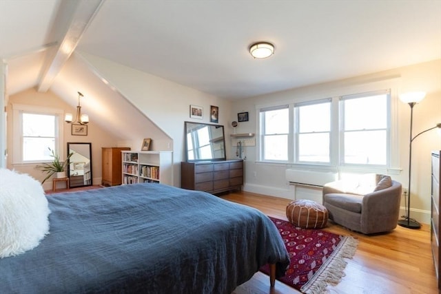 bedroom featuring lofted ceiling with beams, multiple windows, baseboards, and wood finished floors