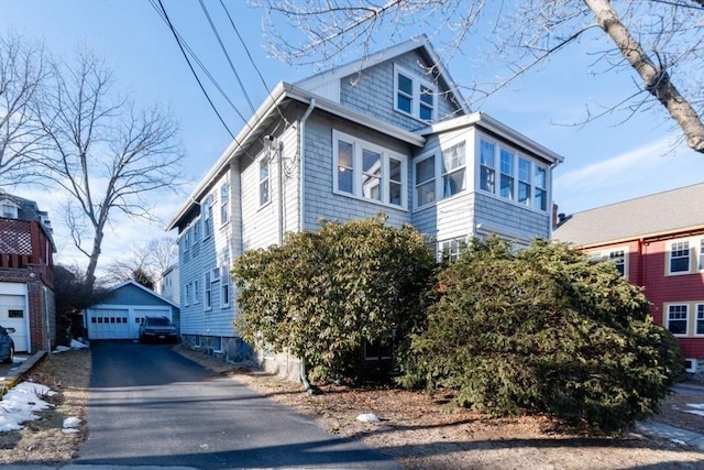 view of front of home with driveway, a garage, and an outdoor structure