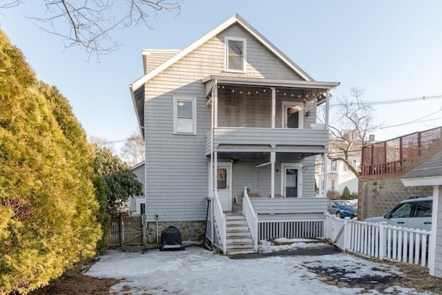 view of front of house with fence and a balcony