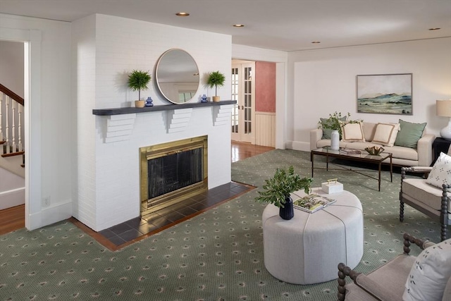 living room featuring a brick fireplace, stairway, recessed lighting, and baseboards