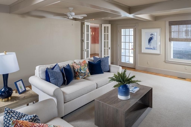 living area featuring visible vents, beam ceiling, wood finished floors, baseboards, and ceiling fan