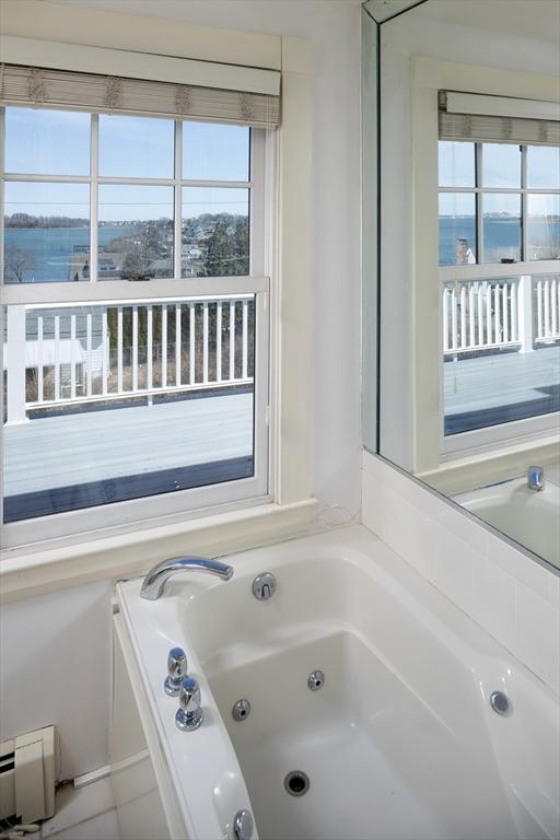 full bath featuring baseboard heating and a whirlpool tub