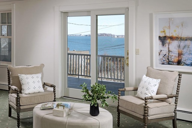 sitting room featuring a baseboard heating unit and a water view