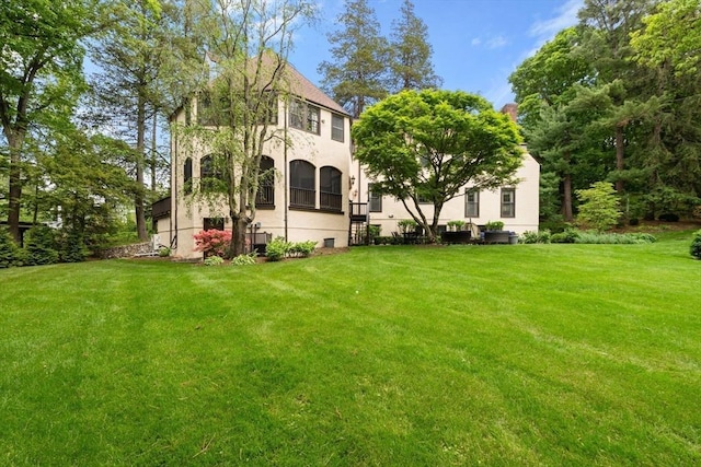 85 Gate House Rd, Newton, MA 02467 - back of property with stucco siding and a yard