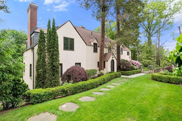 85 Gate House Rd, Newton, MA 02467 - view of home's exterior with stucco siding, a yard, and a chimney
