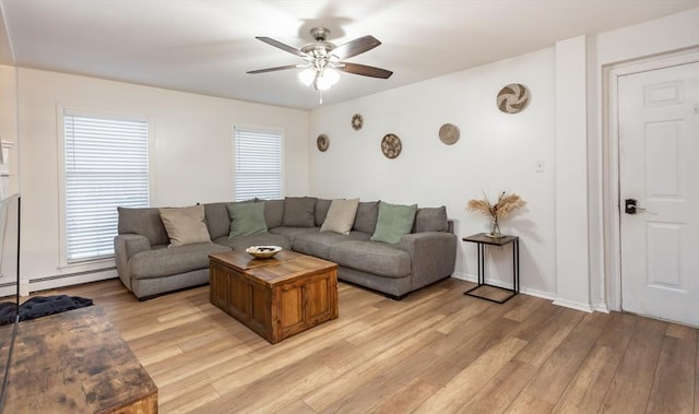 living room featuring ceiling fan, a baseboard heating unit, and light wood-type flooring