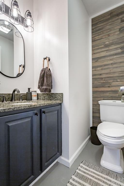 bathroom featuring vanity, toilet, and concrete flooring